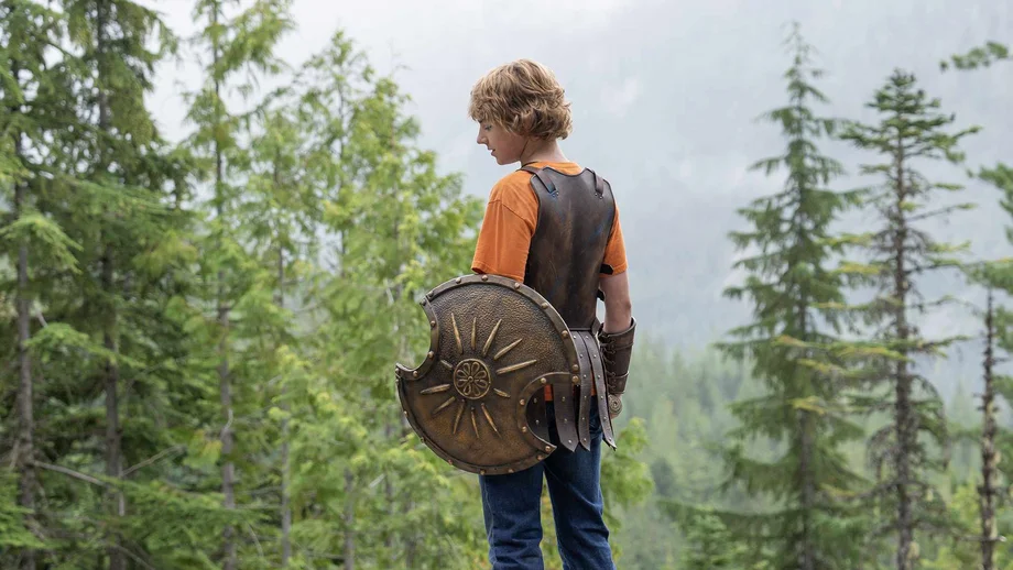 Percy Jackson mit einem Schild im Wald - bereit für einen Kampf.