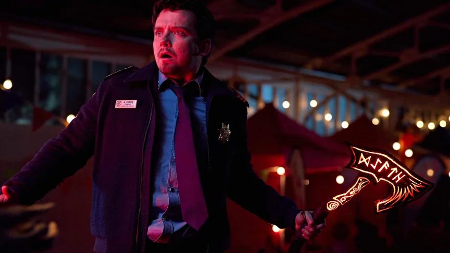 Verängstigt steht Kleinstadtpolizist Arnold (Asa Butterfield) in der Serie „Gnomes - Angriff der Killerzwerge“ mit einer leuchtenden Axt in der Hand in nächtlicher Kulisse.