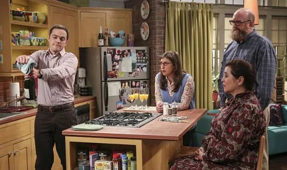 Sheldon (Jim Parsons) müht sich vor den Augen seiner Gäste mit der Sektflasche ab. &copy; CBS